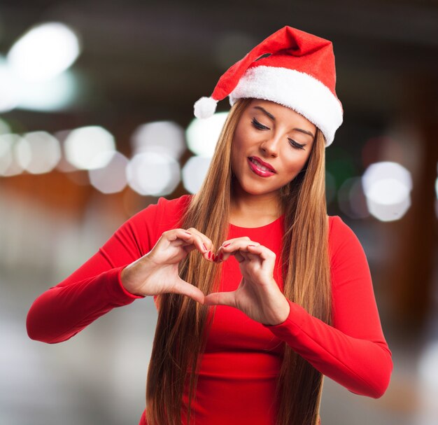 Mujer joven celebrando la navidad con un corazón