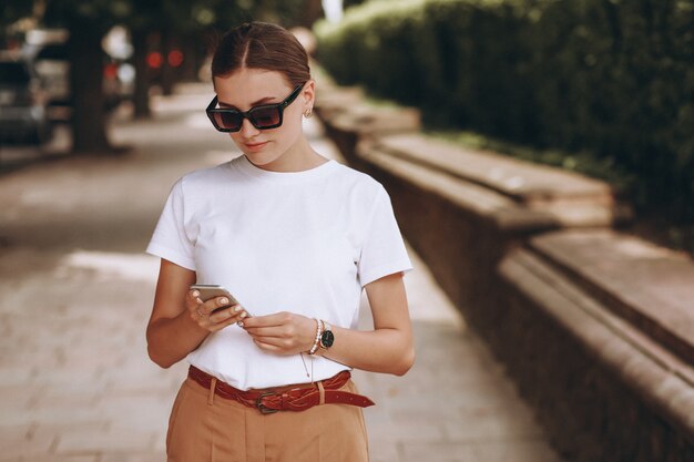 Mujer joven en el centro de la ciudad hablando por teléfono