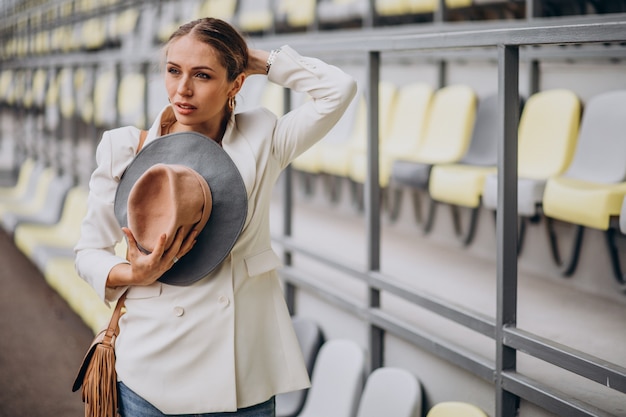 Mujer joven, en, chaqueta blanca, tenencia, sombrero