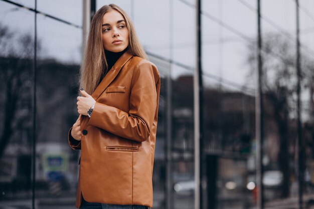 Mujer joven en chaqueta caminando en la ciudad