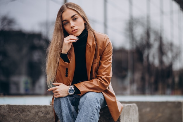 Mujer joven en chaqueta caminando en la ciudad