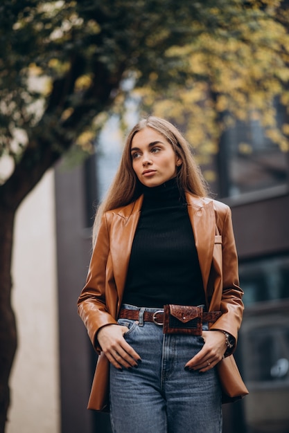 Mujer joven en chaqueta caminando en la ciudad