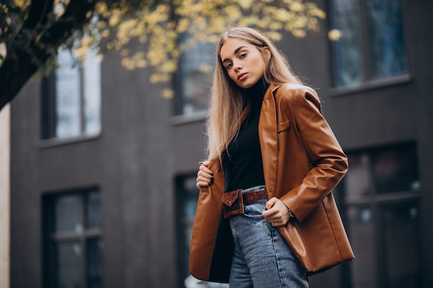 Mujer joven en chaqueta caminando en la ciudad