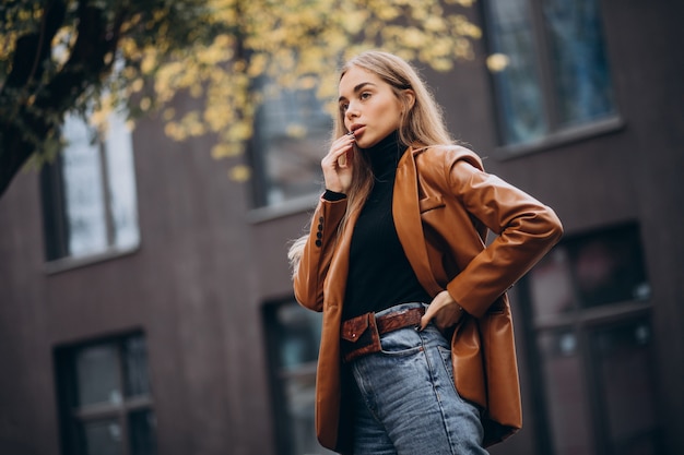 Mujer joven en chaqueta caminando en la ciudad