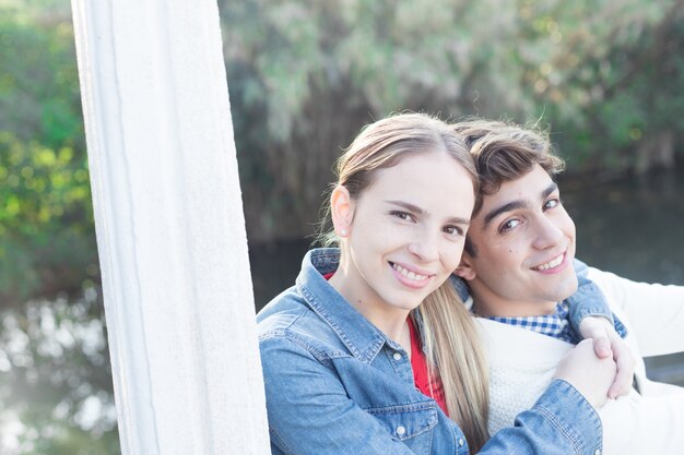 Mujer joven con chaqueta vaquera y abrazando a su novio