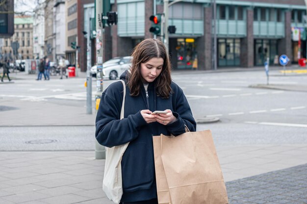 Una mujer joven en la ciudad en la calle con un concepto de compra de paquetes
