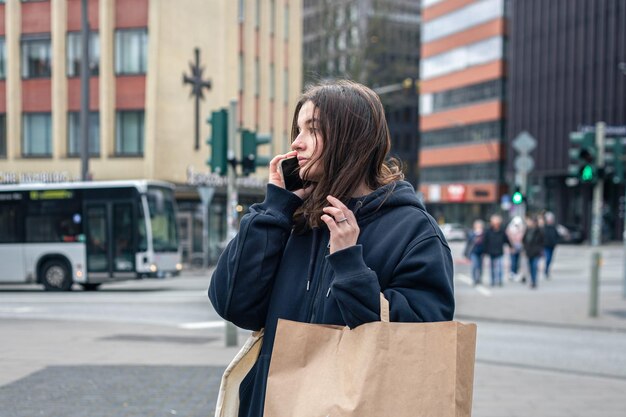 Una mujer joven en la ciudad en la calle con un concepto de compra de paquetes