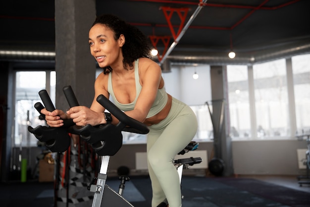 Foto gratuita mujer joven en clase de spinning