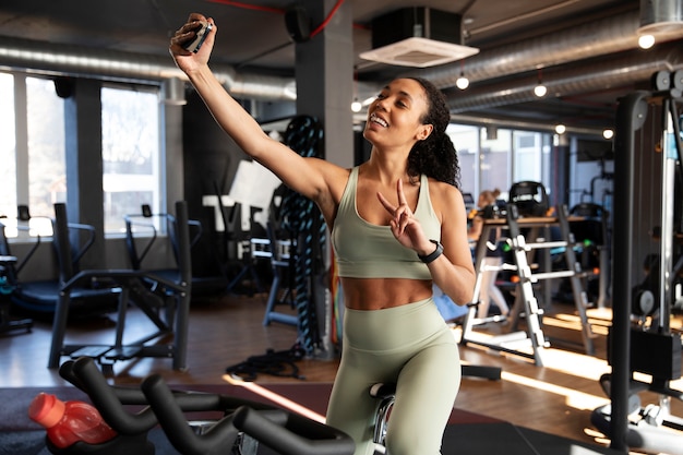 Foto gratuita mujer joven en clase de spinning