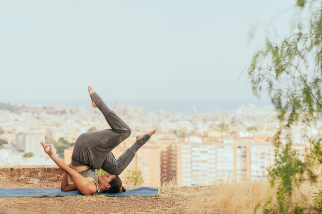 Mujer joven en clase de yoga al aire libre