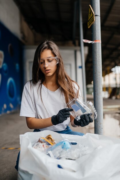Mujer joven clasificando la basura
