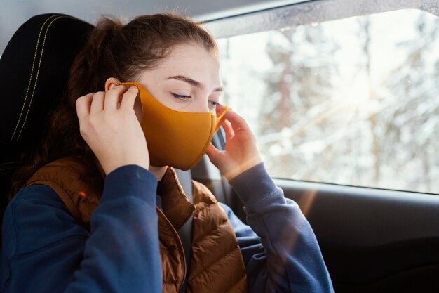 Mujer joven, en coche, llevando, máscara