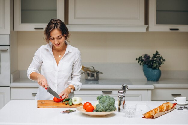 Mujer joven en la cocina preparando el desayuno