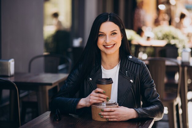 Mujer joven con comida para llevar en el café