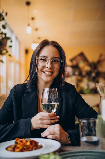 Mujer joven comiendo pasta en un café