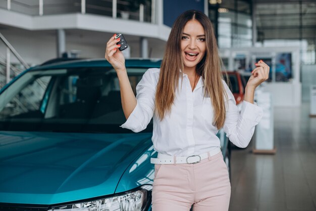 Mujer joven comprando un coche en una sala de exposición de coches