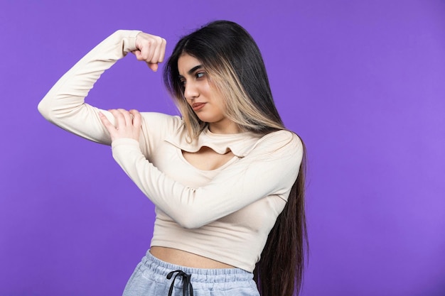 Mujer joven comprobando sus bíceps Foto de alta calidad