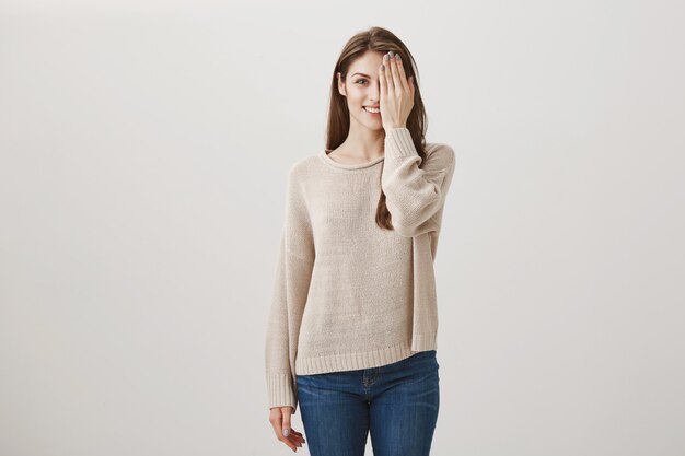 mujer joven comprobando la vista, con la mitad de la cara y sonriendo. Antes y después del concepto