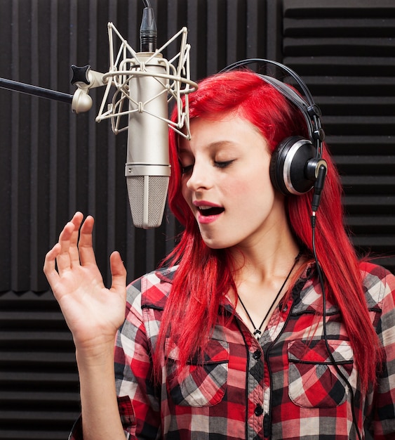 Foto gratuita mujer joven concentrada cantando