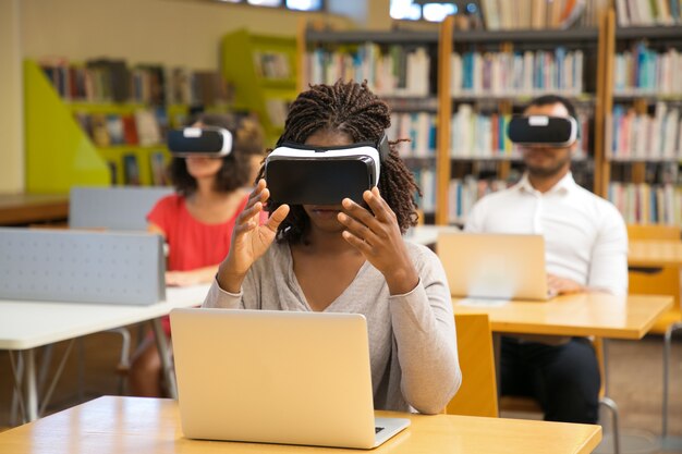 Mujer joven concentrada con gafas de realidad virtual