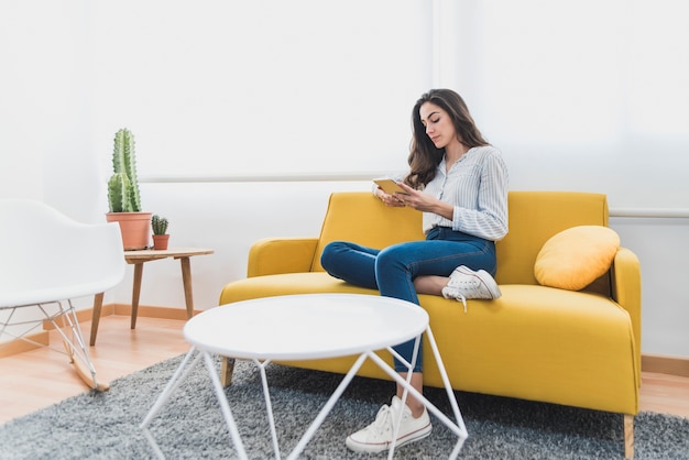 Mujer joven concentrada trabajando con su tableta