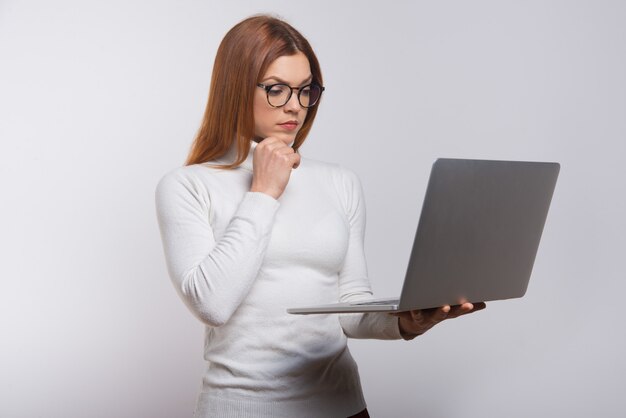 Mujer joven concentrada usando laptop