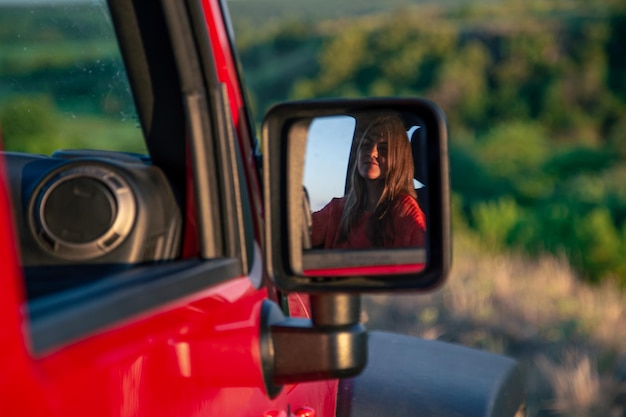 Una mujer joven conduciendo un todoterreno en el campo.