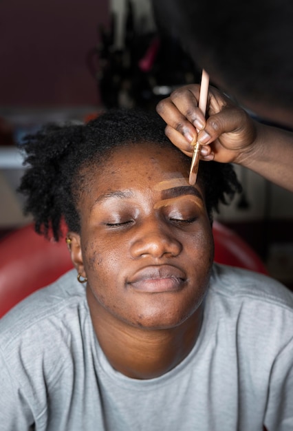 Foto gratuita mujer joven consiguiendo sus cejas en el salón