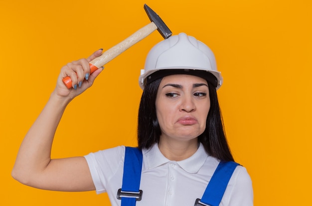 Mujer joven constructor en uniforme de construcción y casco de seguridad