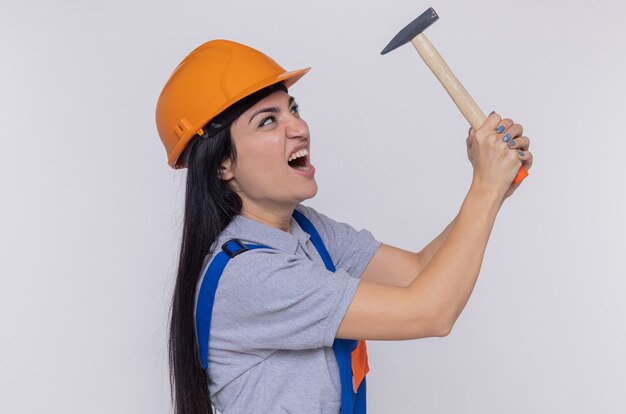 Mujer joven constructor en uniforme de construcción y casco de seguridad