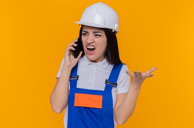 Mujer joven constructor en uniforme de construcción