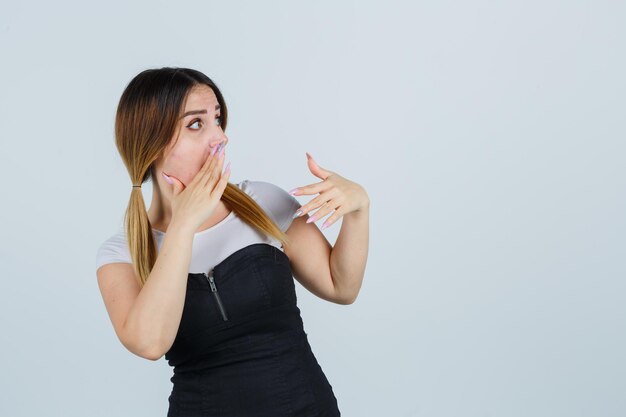 Mujer joven contando un secreto y mirando sorprendido