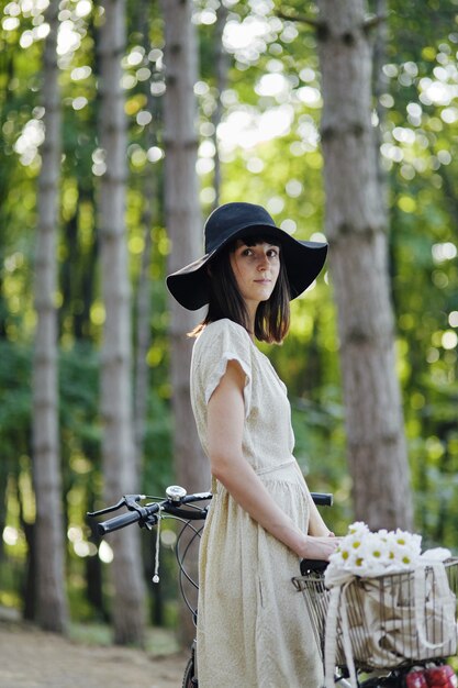 Mujer joven contra el fondo de la naturaleza con bicicleta