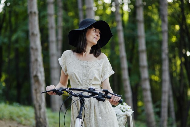 Mujer joven contra el fondo de la naturaleza con bicicleta