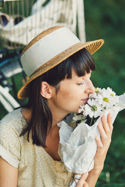 Mujer joven contra el fondo de la naturaleza con bicicleta