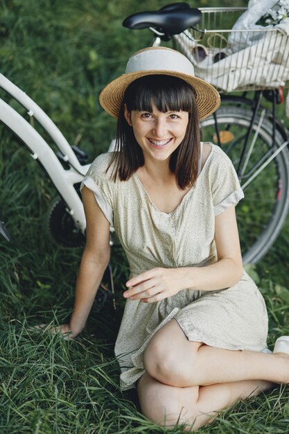 Mujer joven contra el fondo de la naturaleza con bicicleta