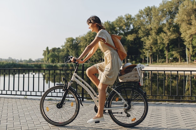 Mujer joven contra el fondo de la naturaleza con bicicleta