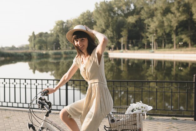 Mujer joven contra el fondo de la naturaleza con bicicleta