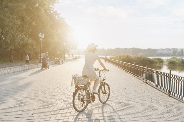 Mujer joven contra el fondo de la naturaleza con bicicleta