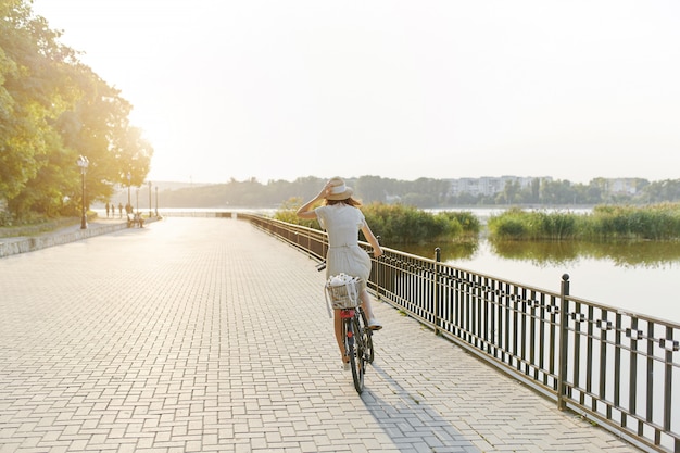 Foto gratuita mujer joven contra el fondo de la naturaleza con bicicleta