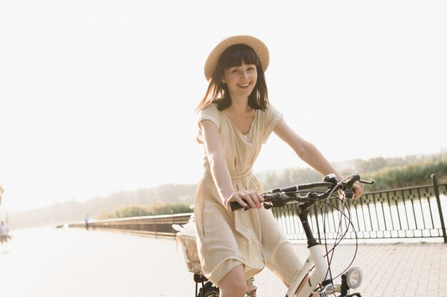 Mujer joven contra el fondo de la naturaleza con bicicleta