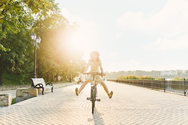 Mujer joven contra el fondo de la naturaleza con bicicleta