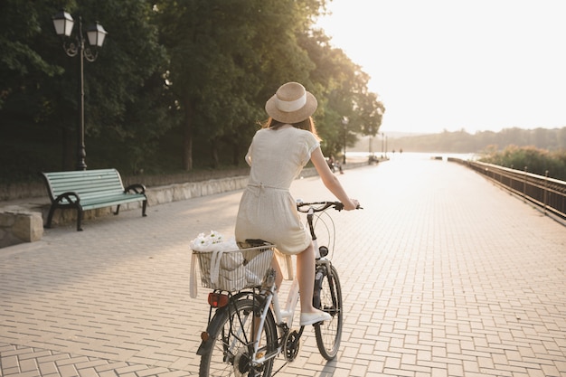 Mujer joven contra el fondo de la naturaleza con bicicleta