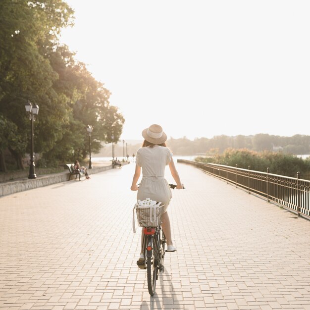 Mujer joven contra el fondo de la naturaleza con bicicleta