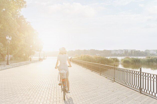 Mujer joven contra el fondo de la naturaleza con bicicleta