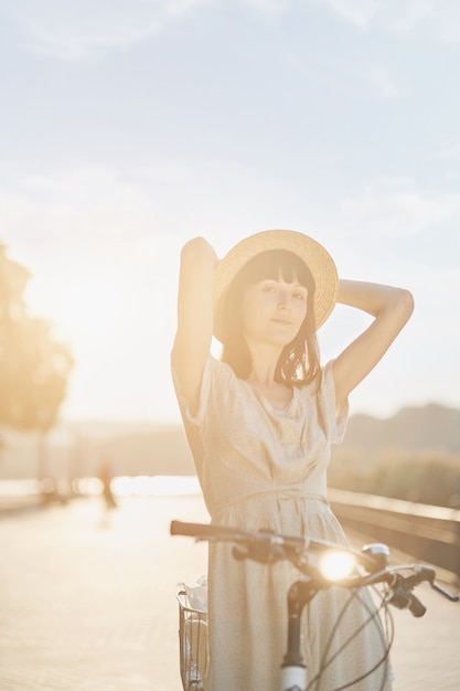 Foto gratuita mujer joven contra el fondo de la naturaleza con bicicleta