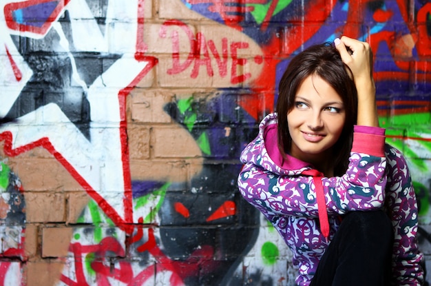 Mujer joven contra la pared con graffiti