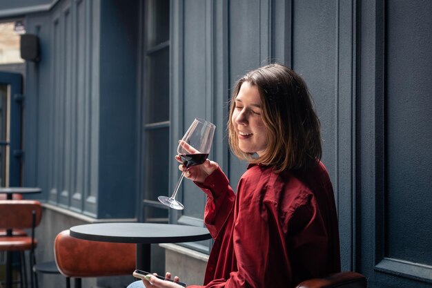 Una mujer joven con una copa de vino en la terraza de un restaurante