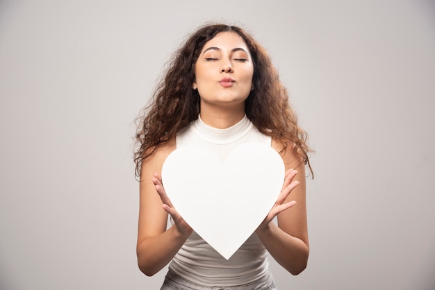 Foto gratuita mujer joven con corazón de papel hecho a mano blanco. foto de alta calidad