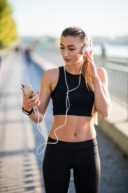 Mujer joven corriendo en un camino rural durante la puesta de sol